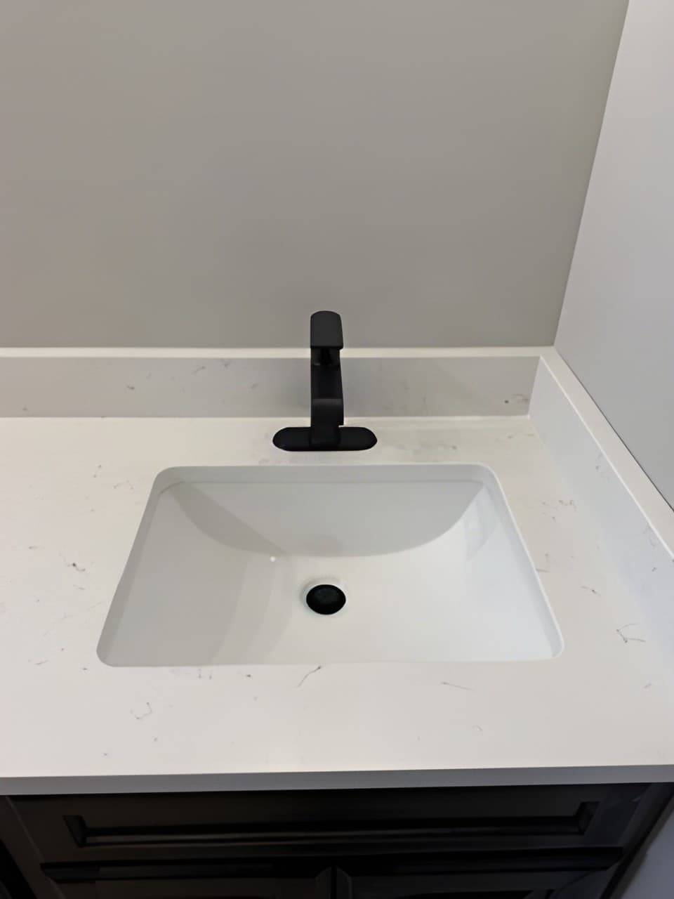 New quartz-top vanity with a black faucet installed by Drew Davis Plumbing